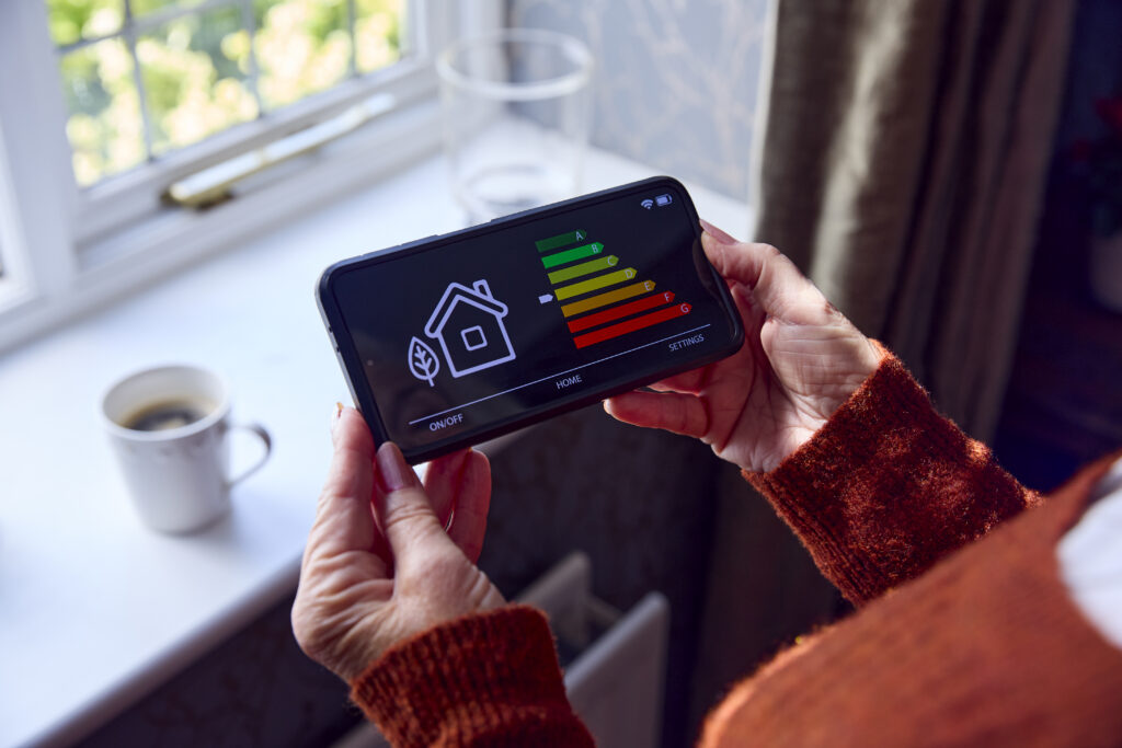 Homeowner checking smart device to improve home energy savings in Maryland during colder months.