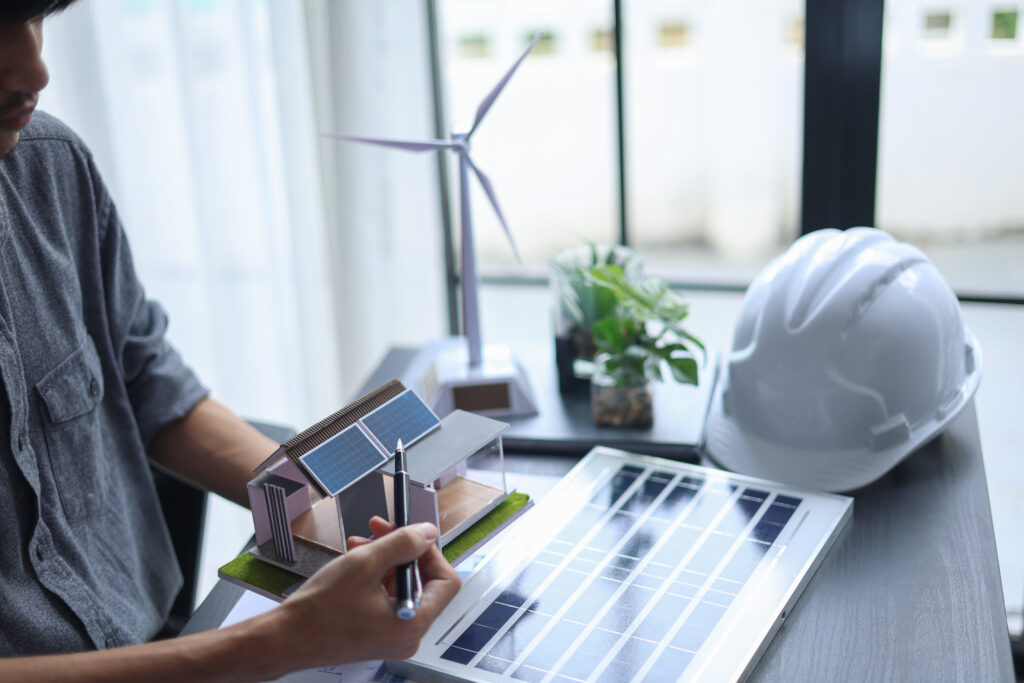 Architect reviewing sustainable home design plans during an energy audit to improve efficiency and reduce energy costs.