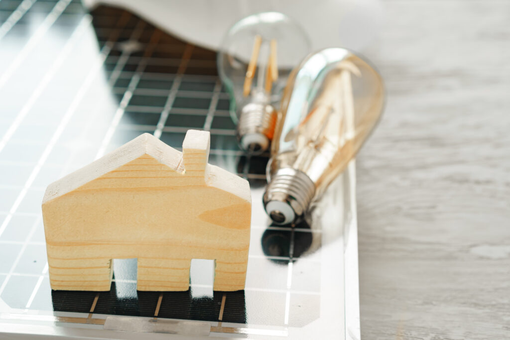 Miniature house model with solar panel representing energy audit insights for improving home efficiency and savings.