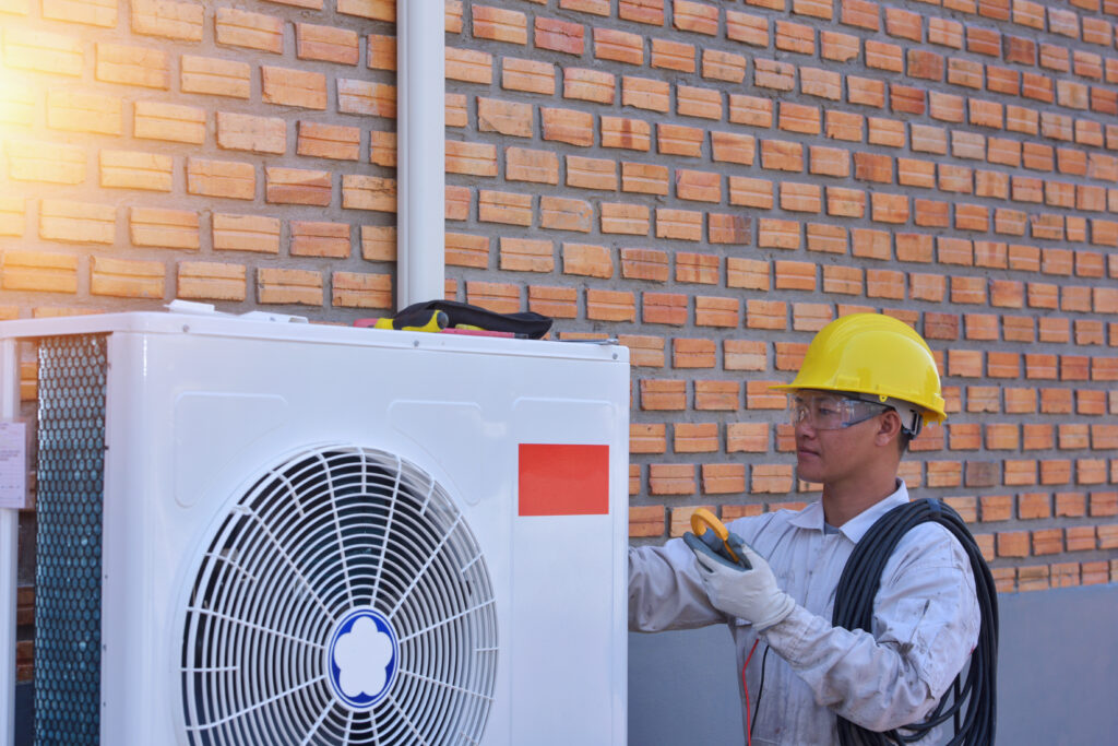 HVAC system replacement in progress with technician removing an older inefficient unit.