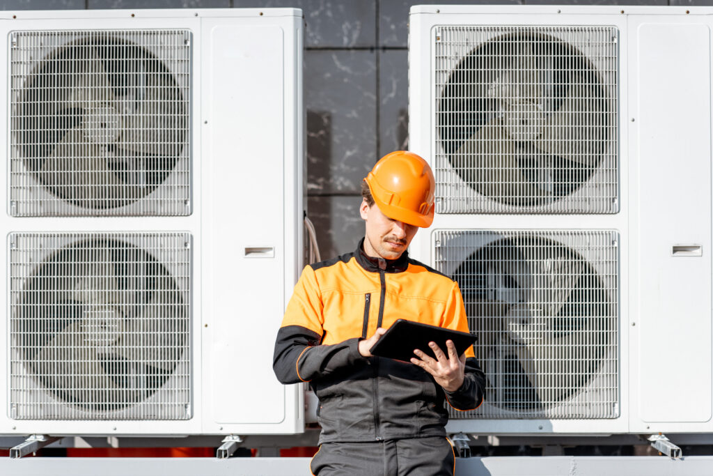 HVAC technician inspecting outdoor cooling units to evaluate system performance and efficiency.